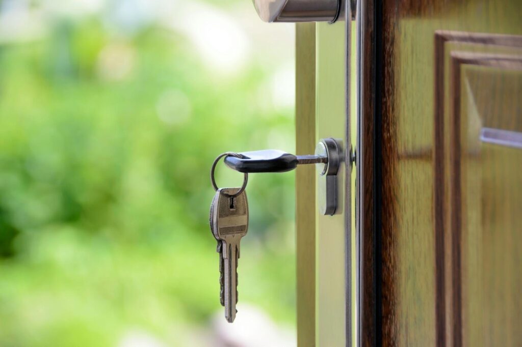 House keys inserted into a front door lock, representing home access and security